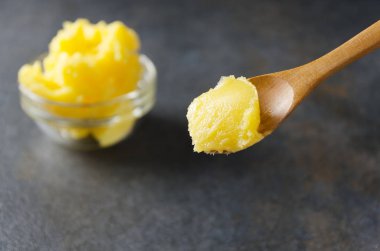 Organik yemek pişirme için sağlıklı bir madde. Kaşık ghee veya açıklık tereyağı, closeup ile