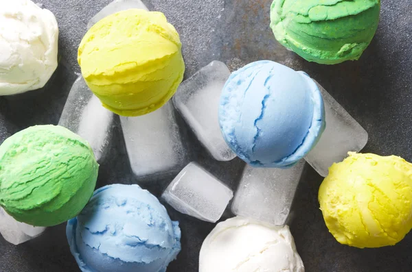 Delicious ice cream balls with different flavours served on ice cubes, top view