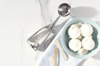 Güneşli yaz günü. Vanilyalı dondurma topları, mavi tabağı, peçete ve buz crem kaşık, hizmet veren görünüm top