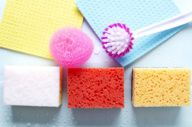 Mavi ıslak yüzeyde üstten görünüm renkli temizlik araçları. Ev temizliği için ürün çeşitli kavramı 