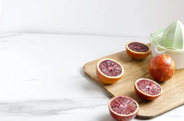 烹饪新鲜美味的血液橙汁 手动榨汁机和切菜板 为您的设计提供空空间 — 图库照片