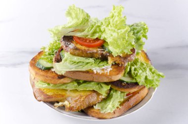 Tabak üzerinde sebze ile lezzetli tost yığını, beyaz mermer masa