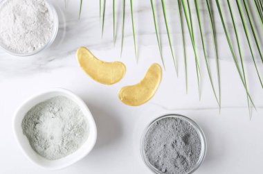 Modern göz maskesi closeup, beyaz mermer yüzeyinde farklı türde kozmetik kil çeşitliliği. Güzellik prosedürleri konsepti