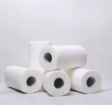 Beyaz ahşap duvara karşı beyaz mermer yüzeyinde kağıt havlu yığını