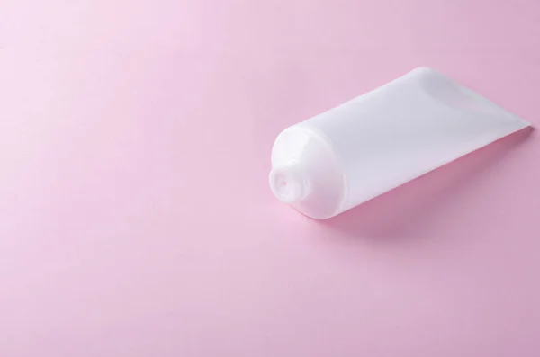 ピンクの背景に化粧品クリームと白いプラスチックチューブクリームの化粧品パッケージ デザインのための空のスペース — ストック写真