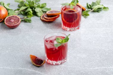 Buz küpleri ile soğuk kanlı margarita. Gri masada alkollü içecek ile servis edilen bardaklar