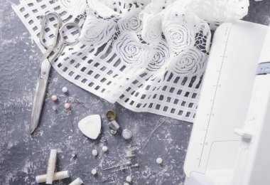 Dikiş masası ve beyaz kumaş, dikiş araçları ve ekipmanları üst görünümü