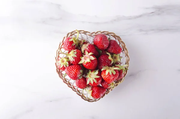 Sweet strawberries in the little basket.Symbol of love. Heart shape bowl, summer juicy strawberries