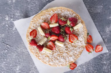 Sünger kek, çilek ve çikolata parçaları üst görünümü. Pişirme kağıdında lezzetli kek