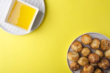 Bal ile derin kızarmış peynir topları üst görünümü. Renkli yüzeyde lezzetli snack