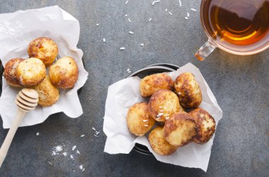 Bal ve sıcak siyah çay fincan ile servis donut delikleri üst görünümü. Kahvaltı için lezzetli ve kolay snack