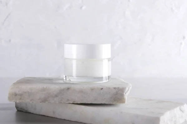 Skin care packaging. Beauty product for face skin, pieces of marble against white background