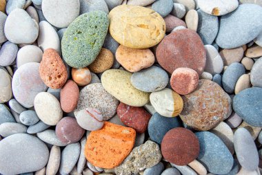 Diverse river stones in multiple colors and sizes, tightly packed together clipart