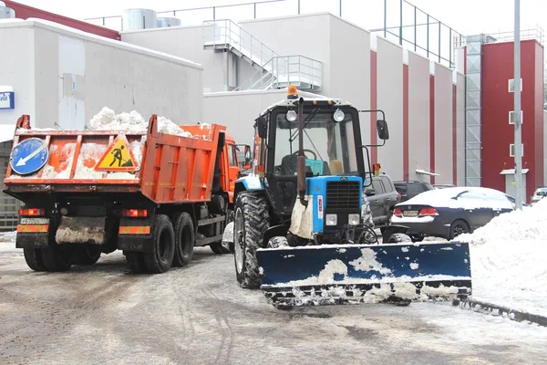 Городские службы уборки снега специальное оборудование после снегопада. городских коммунальных услуг. Трактор загружает снег в грузовик . — стоковое фото