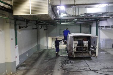 Endüstriyel Bina arabada temelinde sıhhi tesisat temiz kanalizasyon, eseri. İki adam, özel araç, bir merdiven merdiven.