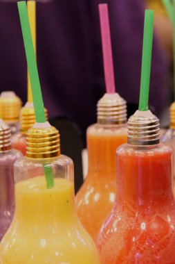 Ampul, parlak renkli yararlı meyve ve sebze suları gıda saman içme ile dolu şeklinde birçok küçük şişe mahkeme karşı yakın çekim