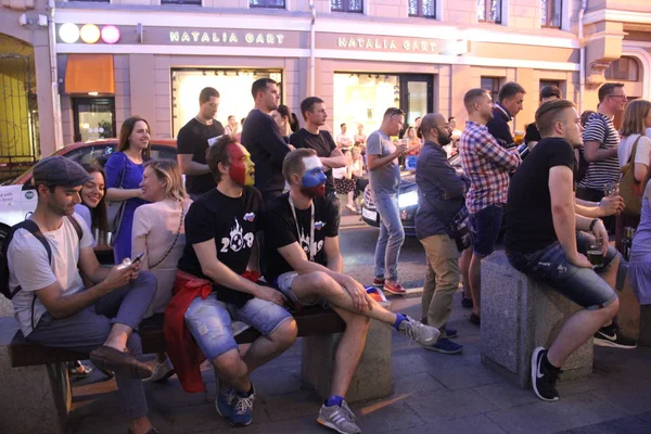 Tres aficionados al fútbol ven el partido transmitido en la cafetería de la ciudad — Foto de Stock