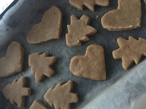 preparing ginger biscuits. cuts out the old knife in the shape of a heart and Christmas tree cookies.