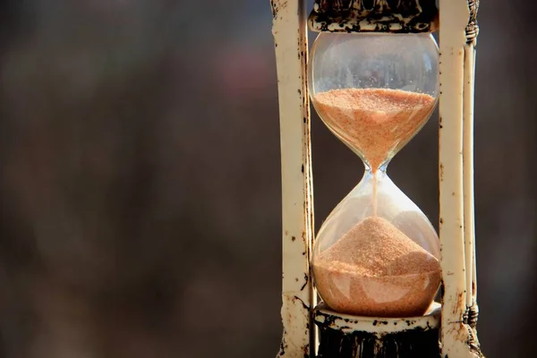 Reloj de arena vintage sobre un fondo gris-marrón — Foto de Stock