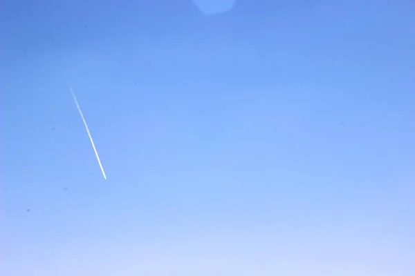 Céu azul e branco traço de um avião voando alto — Fotografia de Stock