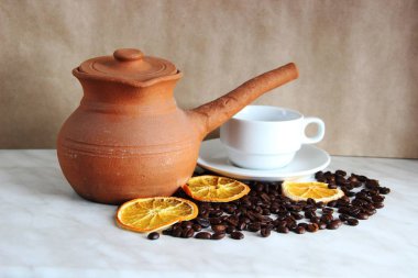kahverengi kil yemekleri, beyaz temiz Fincan ve tabak, kavrulmuş kahve çekirdekleri ve kurutulmuş portakal masada