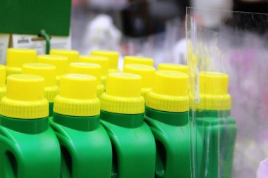 bir satırda yeşil plastik şişeler üzerinde sarı kapaklar. sarı kapaklar ile yeşil plastik şişeler