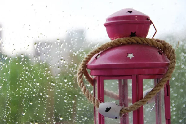 Linterna rosa con una vela encendida en la ventana. espacio para texto a la izquierda —  Fotos de Stock