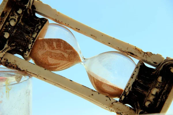 Vintage hourglass tilted diagonally against the blue sky — Stock Photo, Image