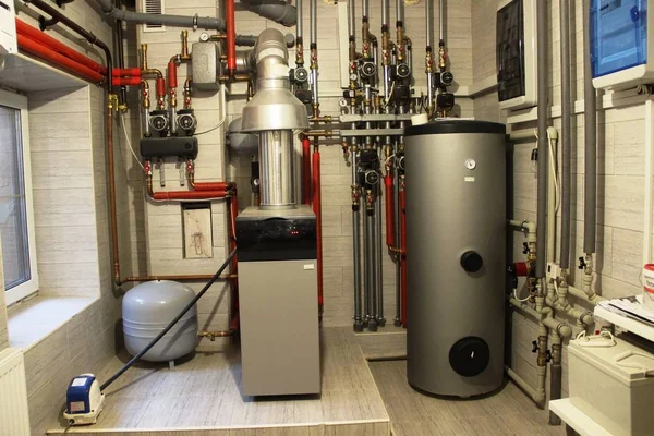 Confort de vie, système de chauffage autonome dans la chaufferie. petite chaudière, chauffe-eau, réservoir d'expansion et autres tuyaux . Image En Vente