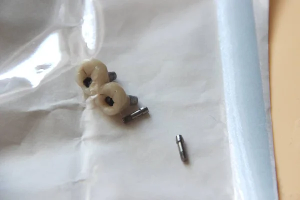 Steril tıbbi zarf, bir diş implantı için çift diş tacı ve montaj için bir çift vida. Seramik insan dişleri veya protezleri.
