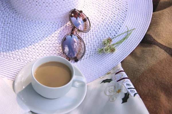 süt, yonca çiçekleri, bardak ve geniş bir ağzına sahip beyaz bir şapka ile kahve beyaz Fincan. yaz brunch
