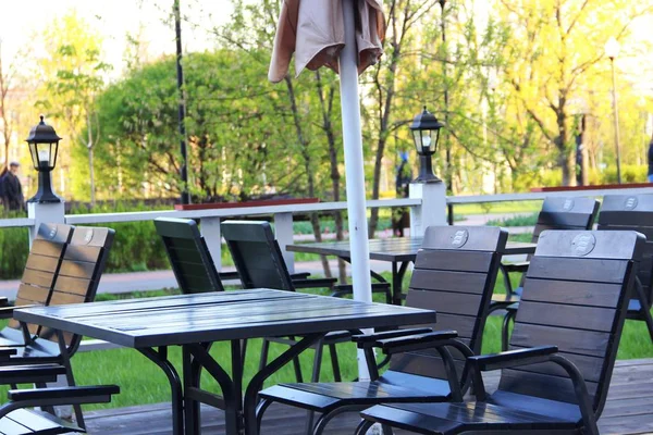 Dřevěné stoly a židle, letní kavárna, bez lidí před otevřením. zavřená letní kavárna. — Stock fotografie