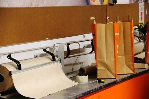 rough wrapping paper, duct tape, paper knife and paper shopping bags, interior in orange tones
