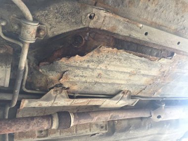 Arabanın paslı ve çürük zemini. Arabanın alt kısmı paslanmış. Aydınlatma ile seçici odak