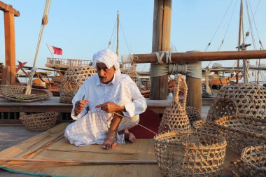 Doha - Katar / Kasım 2017: Kuveytli zanaatkar Katara sahilindeki Dhow festivali sırasında geleneksel balık sepetleri yapıyor