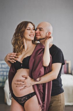 Bir adam yavaşça hugs ve hamile kadını vuruş.