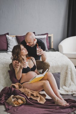 Kocası onun hamile eşi için yatağa kahvaltı getirdim.