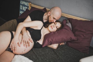 Koca yavaşça onun hamile eşi öper.