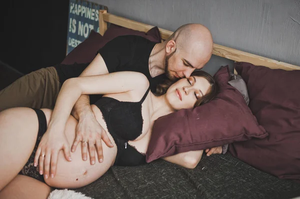 Koca yavaşça onun hamile eşi öper.