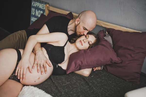 Koca yavaşça onun hamile eşi öper.