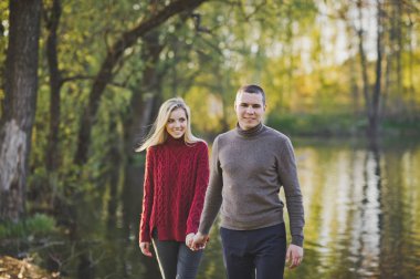 Bir çift aşık gölet kıyı yürür.