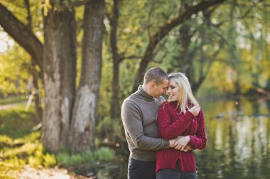 Adam ve kız ayakta gölün kıyısında sarılma.