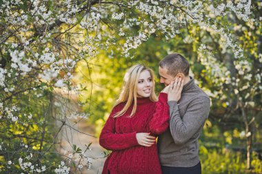 Çiçekli ağaç arka planda aşık çift.