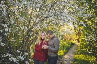 Çiçek açan sokak boyunca aşık yürüyüş.