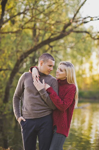 Genç çift ayakta güzel bir gölde sarılma.