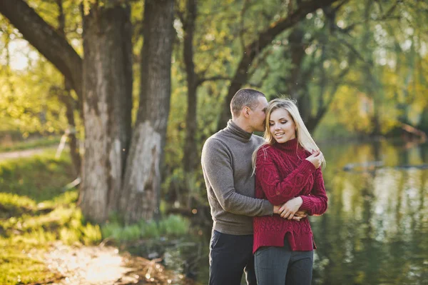 Adam ve kız ayakta gölün kıyısında sarılma.