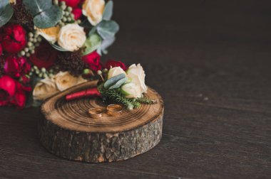 Masanın üzerinde kırmızı ve bej çiçekli buket.