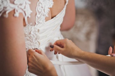 Anne kızının gelinlik giymesine yardım ediyor..