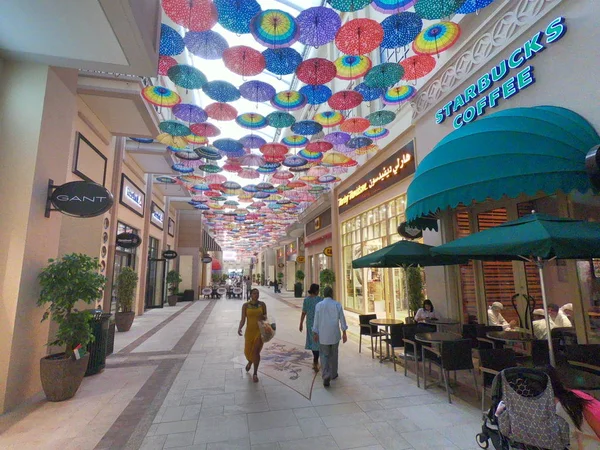Dubai, Emiratos Árabes Unidos febrero 2019 - Starbucks Café cerca de la decoración de paraguas en Dubai Mall. Techo del centro comercial más grande del mundo decorado con coloridos paraguas . — Foto de Stock