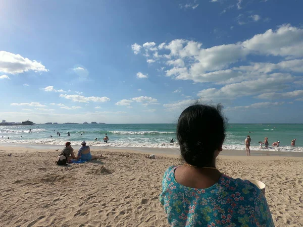 Dubai Emirados Árabes Unidos abril 2019: Mulher olhando para a praia e as águas. Vista de água azul e céu parcialmente nublado. Pessoas não identificadas na praia . — Fotografia de Stock